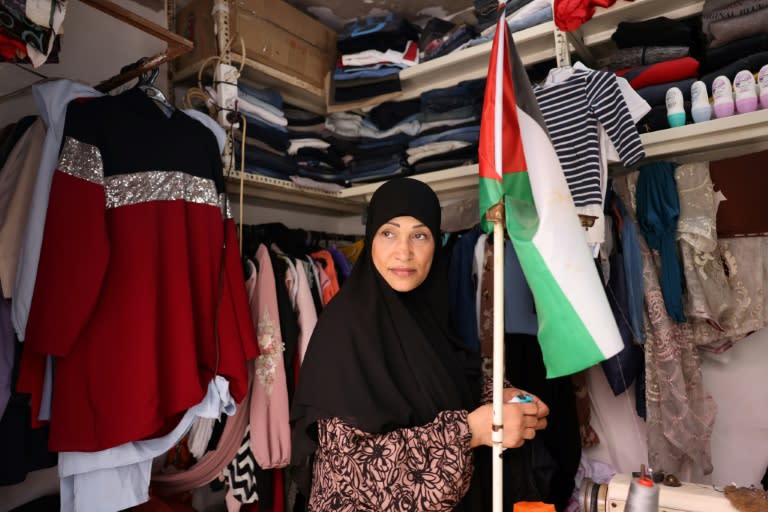 A shop owner carries a Palestinian flag in her store in the Shatila refugee camp in Beirut (ANWAR AMRO)