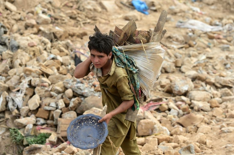 A Pakistani child shifts household items during an operation to demolish a poverty-stricken neighbourhood in Islamabad on July 31, 2015