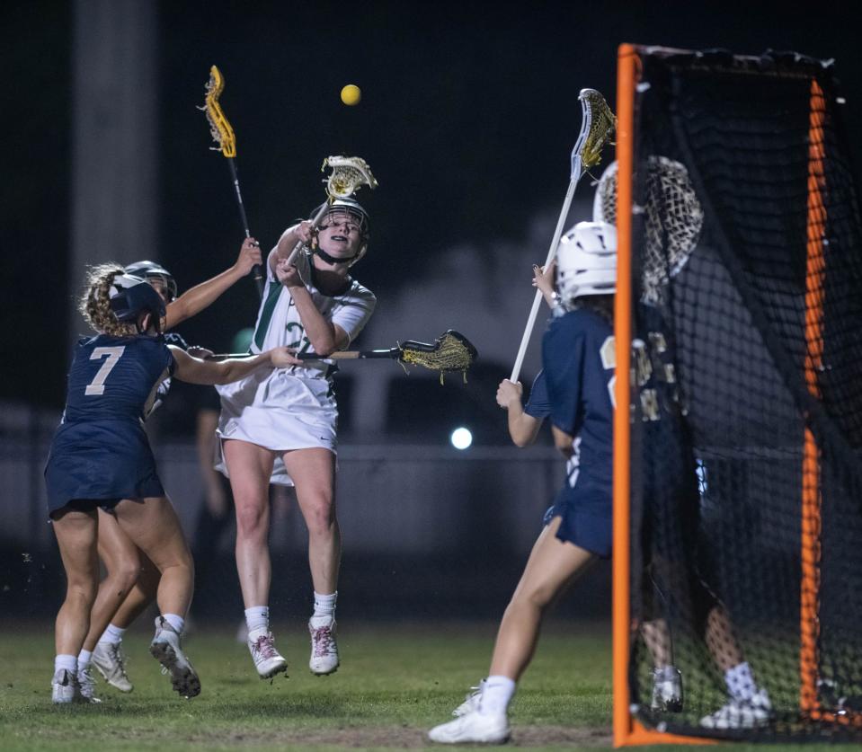 Brinley Christiansen (21) takes a shot on goal during the Gulf Breeze vs Catholic girls lacrosse game at Pensacola Catholic High School on Friday, March 31, 2023.