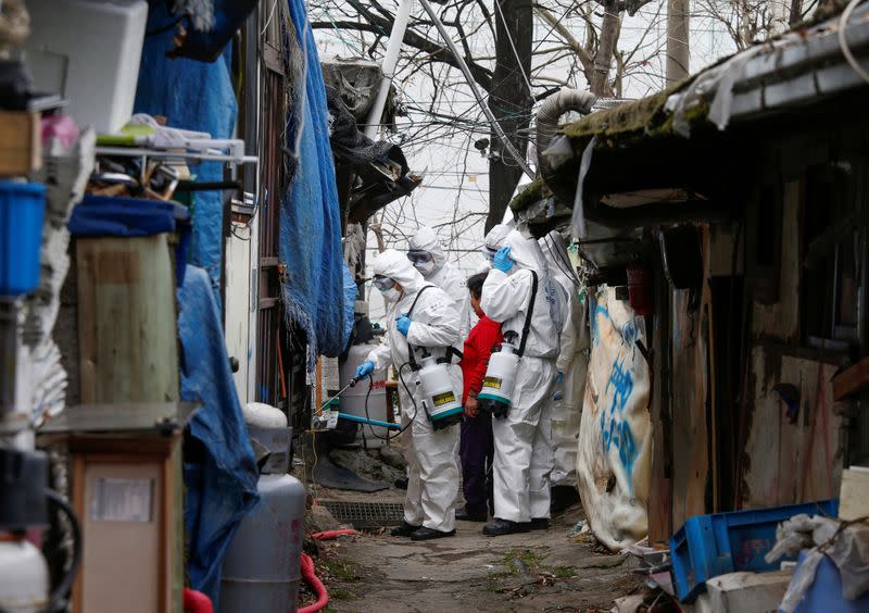 South Korean soldiers in protective gears sanitize shacks at Guryong village in Seoul