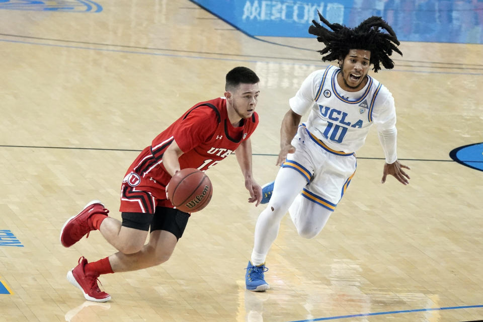 Utah guard Rylan Jones, left, dribbles past UCLA guard Tyger Campbell (10) during the first half of an NCAA college basketball game Thursday, Dec. 31, 2020, in Los Angeles. (AP Photo/Marcio Jose Sanchez)