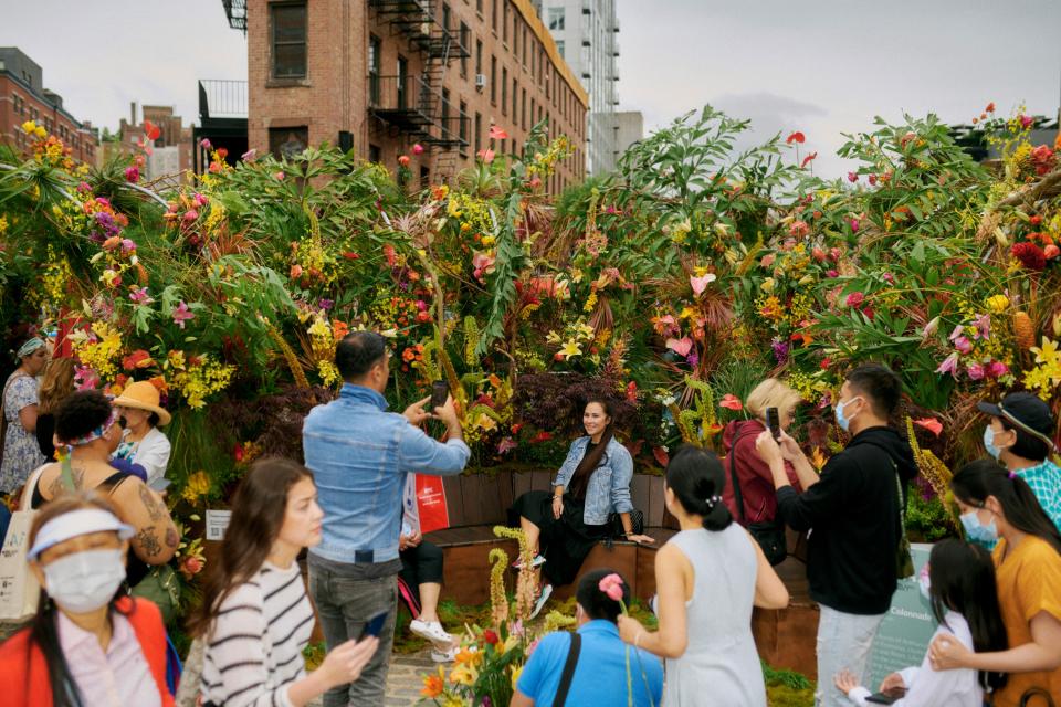 Observers take pictures outside Theresa Rivera Design’s installation, “The Rainbow Colonnade.” It featured anthurium, amranthus, eremusus, roses, lilies, orchids, ginger, and natural landscape elements.