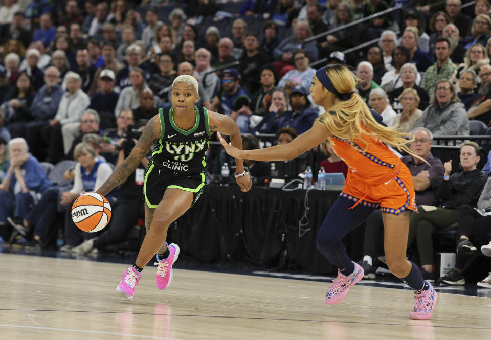 Minnesota Lynx guard Courtney Williams (10) drives with the ball while Connecticut Sun guard DiJonai Carrington (21) blocks during the second half of Game 2 of a WNBA basketball semifinals game, at Target Center, Tuesday, Oct. 1, 2024, in Minneapolis, Minn. The Minnesota Lynx defeated the Connecticut Sun to tie the series 1-1.(AP Photo/Adam Bettcher)