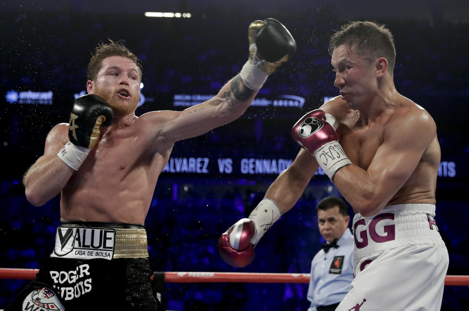 Canelo Alvarez, left, and Gennady Golovkin trade punches in the third round during a middleweight title boxing match, Saturday, Sept. 15, 2018, in Las Vegas. (AP Photo/Isaac Brekken)