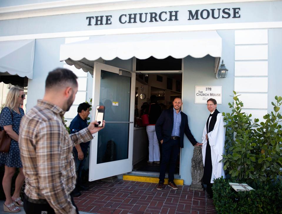 layton Braga, left, and The Rev. Tim Schenck of The Episcopal Church of Bethesda-by-the-Sea pose near a pair of stone lions donated by Devonshire, managed by Braga, at the front door of The Church Mouse on Wednesday.