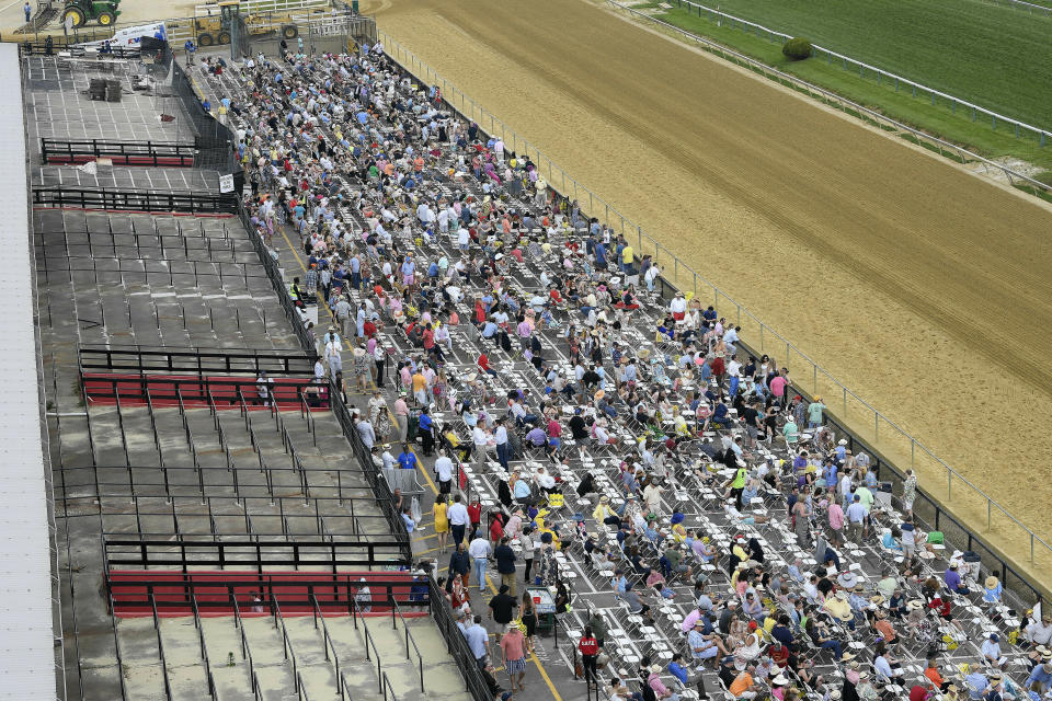 FILE - In this May 18, 2019, file photo, fans sit in front of a condemed section of grandstand ahead of the the 144th Preakness Stakes horse race at Pimlico race course, in Baltimore. The Preakness will remain at Pimlico Race Course into the foreseeable future, thanks to the passing of a bill to redevelop Maryland's race tracks with $375 million in bonds. (AP Photo/Nick Wass, File)