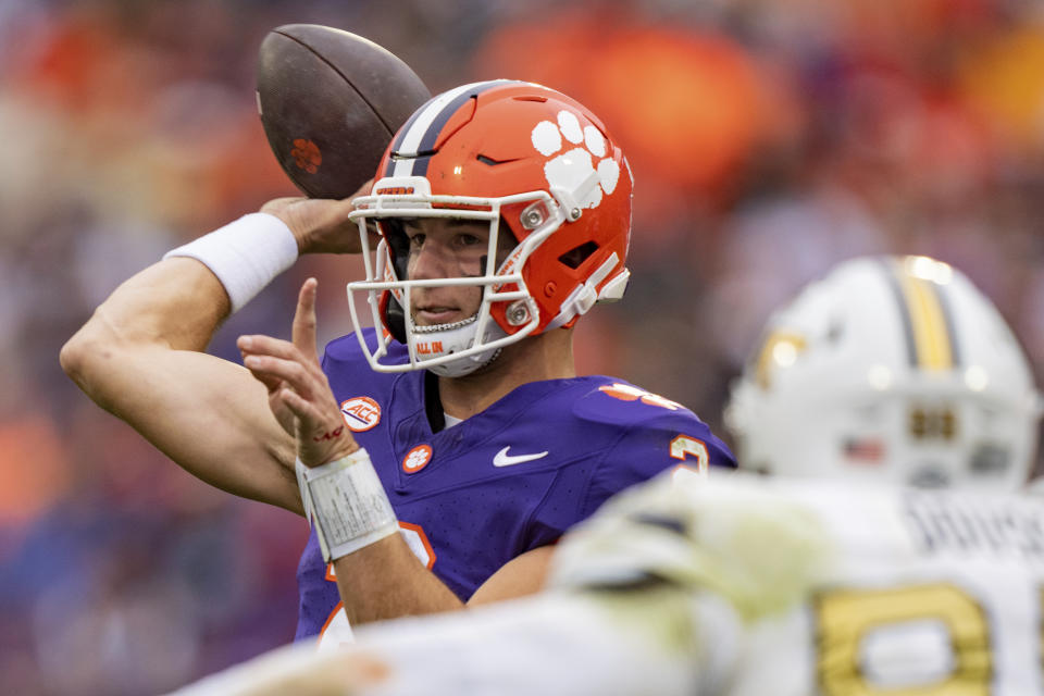 Clemson quarterback Cade Klubnik (2) passes the ball while pressured by Georgia Tech defensive lineman D'Quan Douse (99) during the first half of an NCAA college football game Saturday, Nov. 11, 2023, in Clemson, S.C. (AP Photo/Jacob Kupferman)