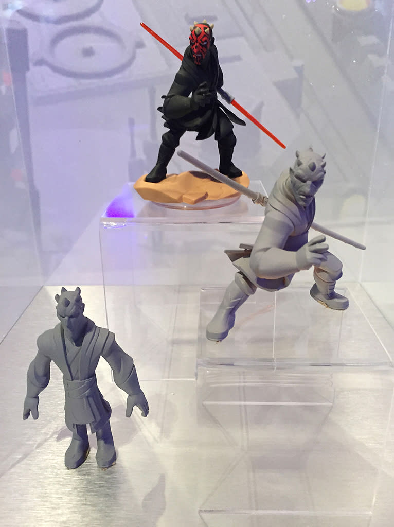 Display shows the progression from 3-D character study (bottom) to prototype (middle) fo final figure (top).