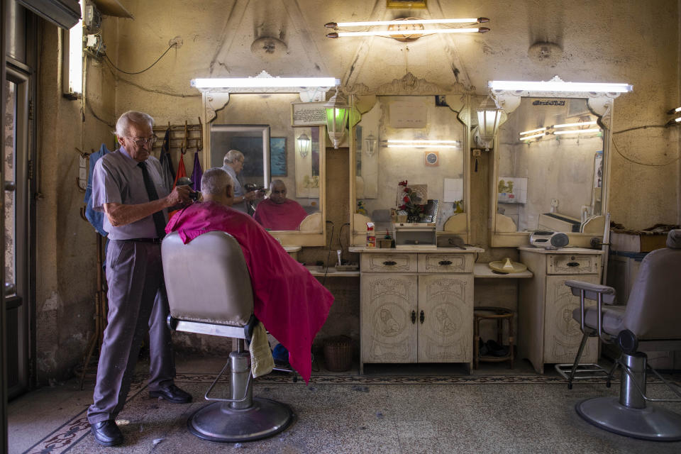 In this Friday, Sept. 27, 2019 photo, an Israeli Arab man gets his haircut at a barber shop in Nazareth, northern Israel. Electoral gains made by Arab parties in Israel, and their decision to endorse one of the two deadlocked candidates for prime minister, could give them new influence in parliament. But they also face a dilemma dating back to Israel's founding: How to participate in a system that they say relegates them to second-class citizens and oppresses their Palestinian brethren in Gaza and the occupied West Bank. (AP Photo/Oded Balilty)