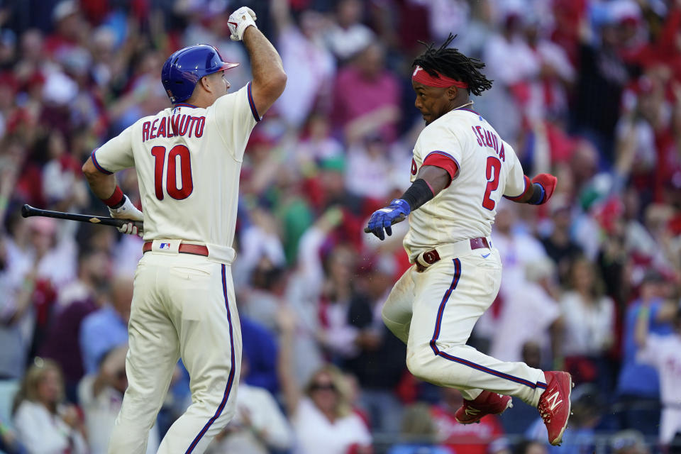 Philadelphia Phillies J.T. Realmuto (10) celebrates with Philadelphia Phillies Jean Segura (2) after Realmuto's RBI-single during the sixth inning in Game 4 of baseball's National League Division Series between the Philadelphia Phillies and the Atlanta Braves, Saturday, Oct. 15, 2022, in Philadelphia. (AP Photo/Matt Rourke)