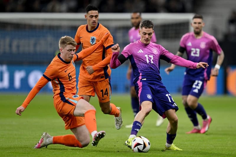 Germany's Florian Wirtz (R) and the Netherlands' Jerdy Schouten (L) and Tijjani Reijnders battle for the ball during the International Friendly soccer match between Germany and Netherlands at the Deutsche Bank Park stadium. Arne Dedert/dpa