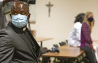 Father Don Ajoko, Phd. surveys the room before a blessing of the hands ceremony for nearly three dozen healthcare workers from around the country who arrived to help supplement the staff at Our Lady of the Lake Regional Medical Center in Baton Rouge, La., Monday, Aug. 2, 2021. Louisiana has one of the lowest coronavirus vaccination rates in the nation and is seeing one of the country’s worst COVID-19 spikes. (AP Photo/Ted Jackson)