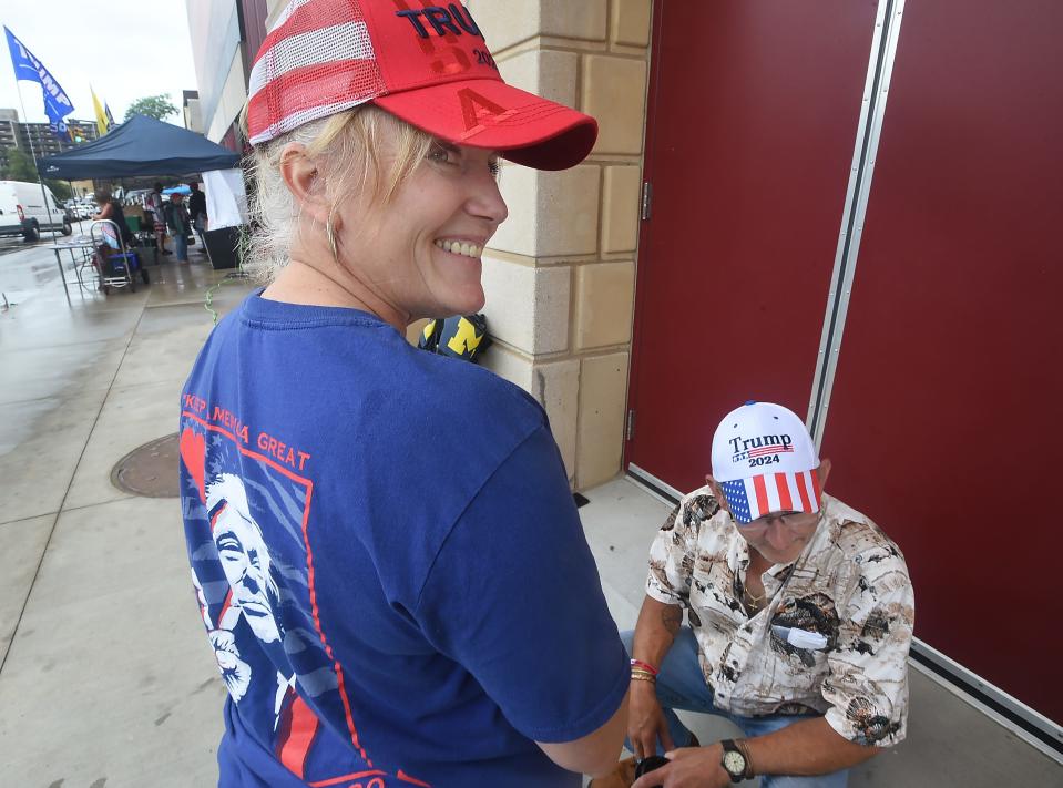 Girard Township residents Nancy Kibbey, 57, and Bob Vanicek, 62, wait near a Warner Theatre door before Erie Insurance Arena opens for the Donald Trump rally in Erie on Saturday. Kibbey, originally from Boston, and Vanicek dispayed recently-purchased souvenirs.