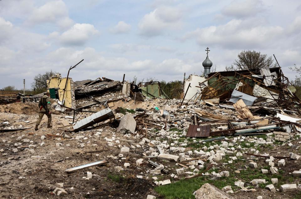 A Ukrainian serviceman walks towards a destroyed house in the village of Yatskivka, eastern Ukraine on April 16, 2022.  / Credit: RONALDO SCHEMIDT/AFP via Getty Images