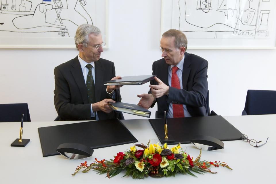 Peter Gottwald, German ambassador in Switzerland, left, and Michael Ambuehl, Switzerland's State Secretary for International Financial and Tax Matters, exchange their folders after the signing of an additional protocol on a tax agreement between Germany and Switzerland in Bern, Switzerland, Thursday, April 5, 2012. (AP Photo/Keystone/Peter Klaunzer)