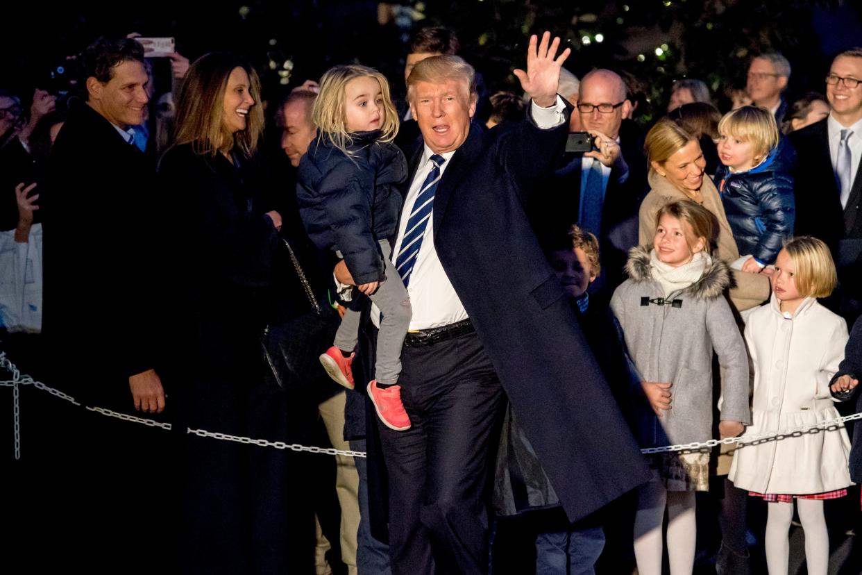 President Donald Trump holds a girl in his arm and waves to members of the media as he arrives at the White House - Copyright 2017 The Associated Press. All rights reserved.