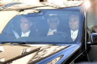 Bernie Ecclestone, center, the 83-year-old controlling business magnate in Formula One racing, sits in a car on his way to the regional court in Munich , Germany, Thursday, April 24, 2014. Ecclestone is charged with bribery and incitement to breach of trust "in an especially grave case" over a US$ 44 million payment to a German banker, that prosecutors allege was meant to facilitate the sale of the Formula One Group to a buyer of Ecclestone's liking. (AP Photo/ Kerstin Joensson)