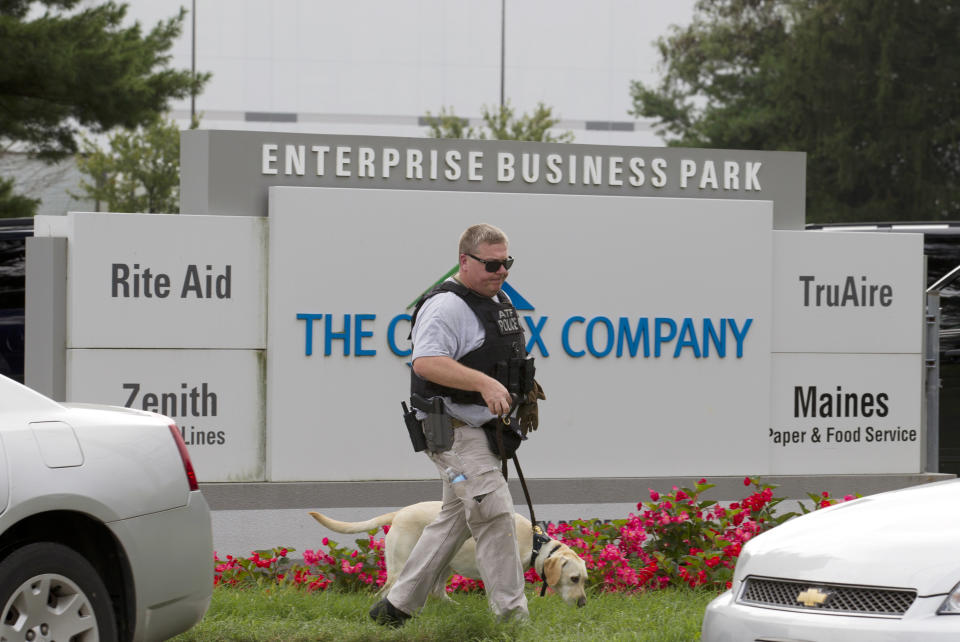 Un agente de la Agencia de Alcohol, Tabaco, Armas de Fuego y Explosivos camina con un perro rastreador afuera de un complejo industrial en Harford, Maryland, el jueves 20 de septiembre de 2018. (AP Foto/Jose Luis Magana)