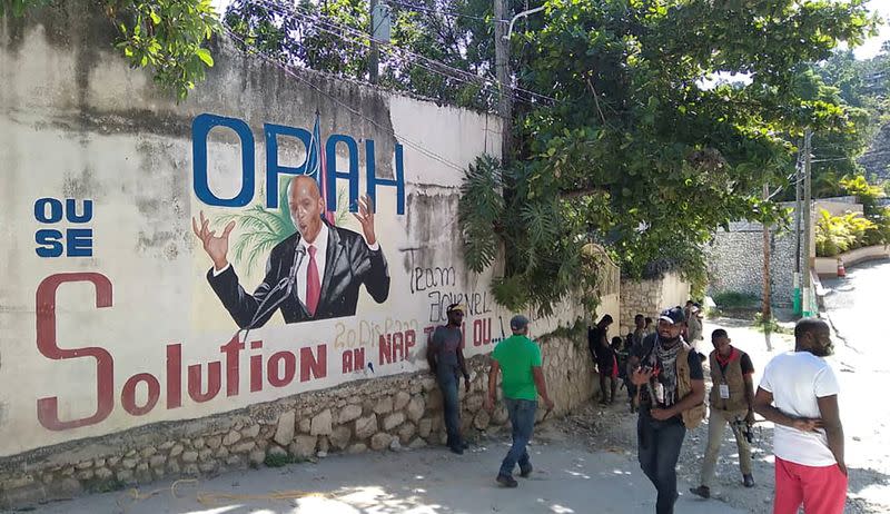 Foto del martes de un grupo de personas pasando frente a un mural que muestra al presidente de Haiti, Jovenel Moise, tras su muerte a manos de hombres armados no identificados en Puerto Príncipe