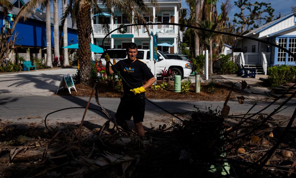 Gregg Fergus cleans up debris in front of homes along Andy Rosse Lane on Captiva on Wednesday, Jan. 4, 2023. 