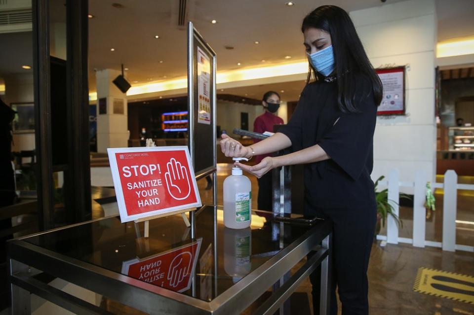 A hotel guest sanitises her hands at the lobby of the Concorde Hotel in Shah Alam June 9, 2020. — Picture by Yusof Mat Isa