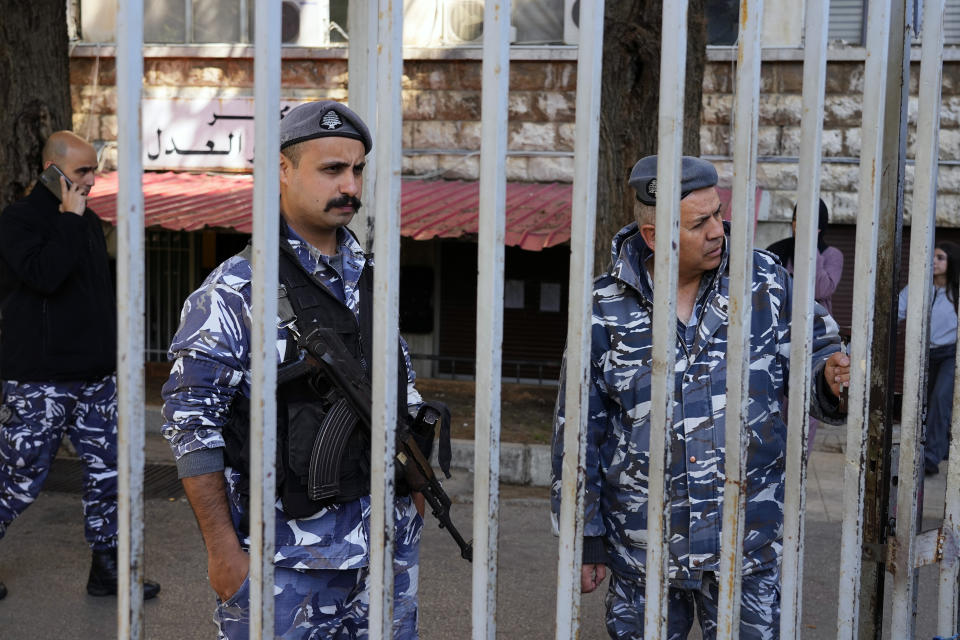 Lebanese police officers stand guard at the entrance of the Justice Palace in Beirut, Lebanon, Thursday, March 16, 2023. Lebanon's embattled Central Bank chief, Riad Salameh, appeared Thursday for questioning for the first time before a European legal team visiting Beirut in a money-laundering probe linked to the governor. (AP Photo/Bilal Hussein)