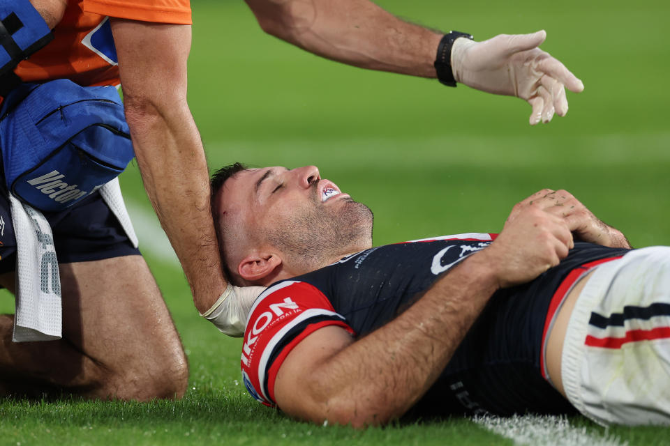SYDNEY, AUSTRALIA - APRIL 05:  James Tedesco of the Roosters  is attended to by a trainer after an attempted tackle on Viliame Kikau of the Bulldogs during the round five NRL match between Canterbury Bulldogs and Sydney Roosters at Accor Stadium on April 05, 2024, in Sydney, Australia. (Photo by Cameron Spencer/Getty Images)