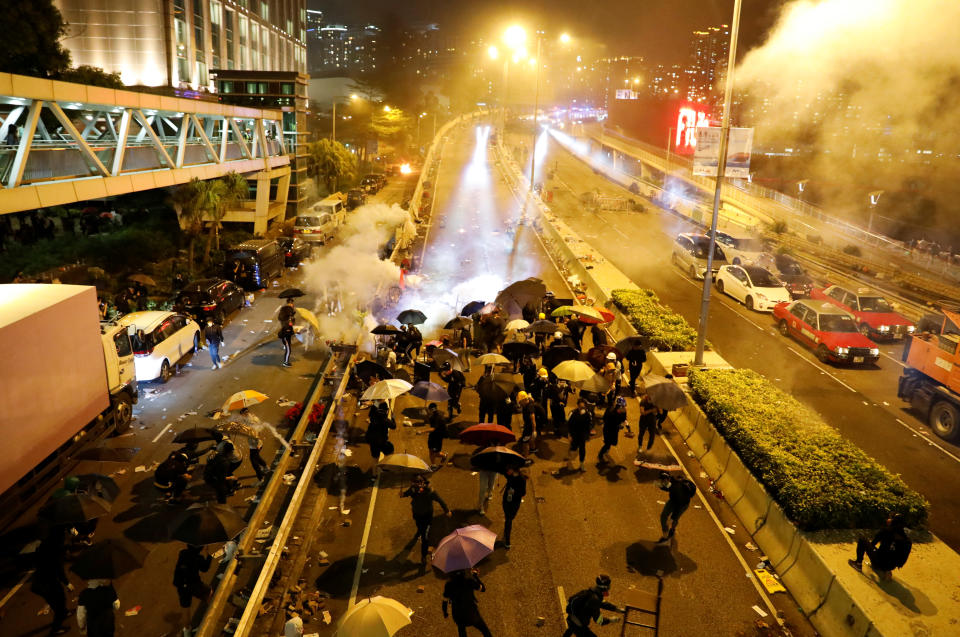 Anti-government demonstrators take cover during clashes with police near the Hong Kong Polytechnic University (PolyU) in Hong Kong, China November 18, 2019. REUTERS/Adnan Abidi