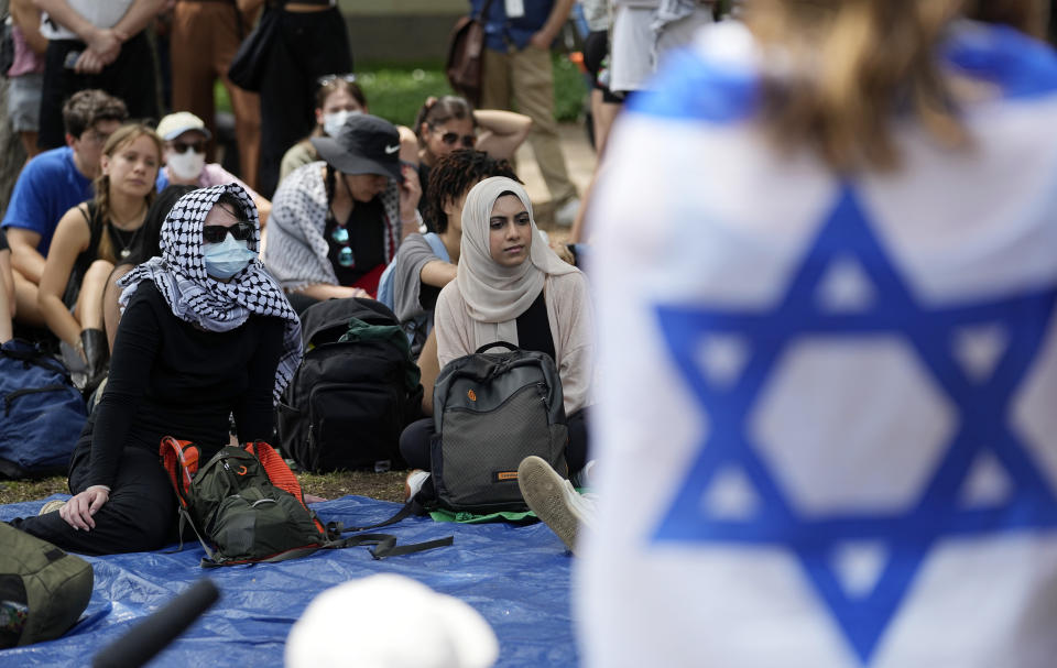 FILE - A student wrapped in an Israeli flag listens to Pro-Palestinian protesters gathered on campus at the University of Texas at Austin, on April 30, 2024, in Austin, Texas. Israeli Prime Minister Benjamin Netanyahu has repeatedly accused critics of Israel or his policies of antisemitism, including the U.S. college campus protests and the prosecutor of the International Criminal Court. (AP Photo/Eric Gay, File)