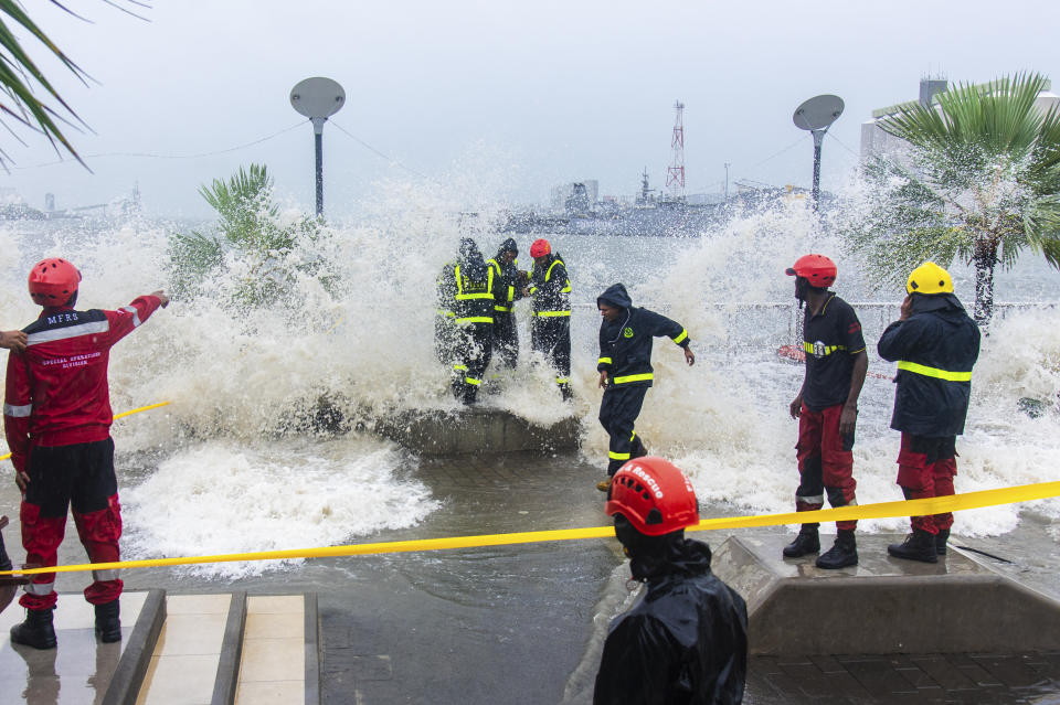 Workers are covered in water from a wave during a cyclone on the Caudan Waterfront in Port Louis, the capital city of Mauritius, Monday Jan. 15, 2024. Mauritius lifted its highest weather alert and eased a nationwide curfew Tuesday after a cyclone battered the Indian Ocean island, causing heavy flooding and extensive damage in the capital city and other parts of the country. (Lexpress.mu via AP)