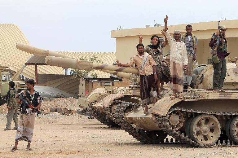 Fighters from local tribes, Popular Resistance Committees and supporters of the southern Yemeni separatist movement, who oppose the Shiite-Huthi movement, stand on a tank at the Al-Anad airbase, north of Aden, on March 24, 2015