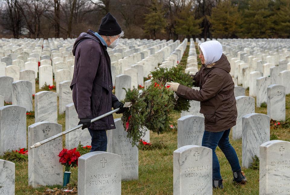 Charlene Lindsey, left, of Holland, steadies the pole as Debbie Eppolito, of Levittown, stacks wreaths from the gravesites at Washington Crossing National Cemetery  in Upper Makefield on Monday, Jan. 17, 2022.