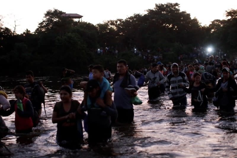 Migrants, mainly from Central America, marching in a caravan cross the Suchiate river on the outskirts of Ciudad Hidalgo