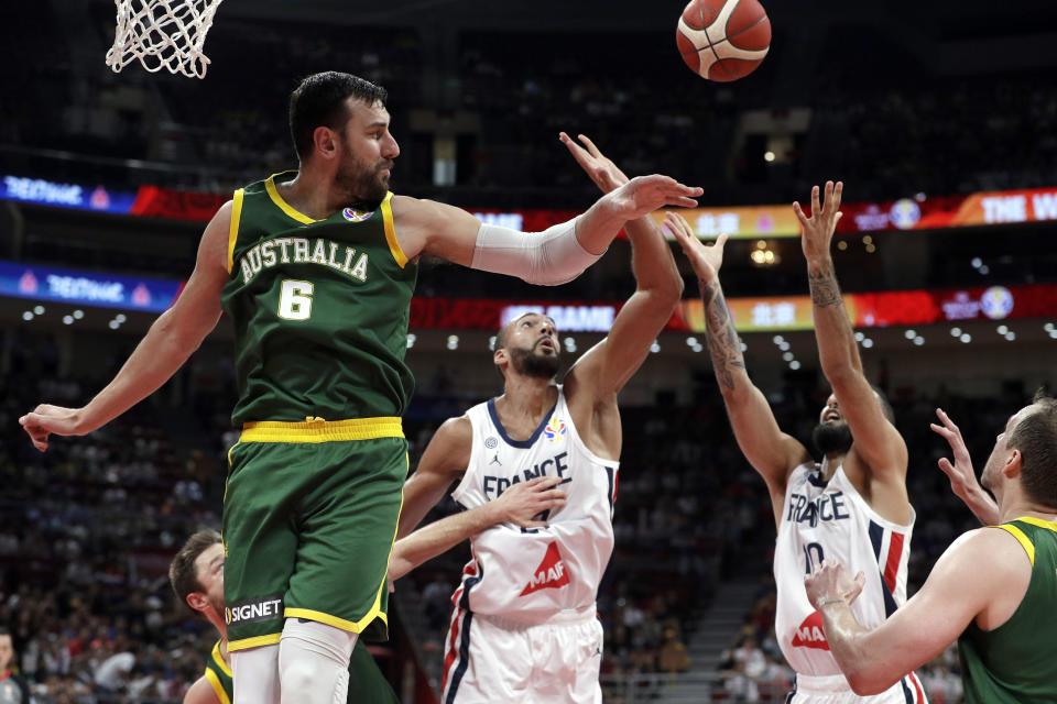 Andrew Bogut of Australia and Rudy Gobert, center, and Evan Fournier of France battle for the ball during their third-place match in the FIBA Basketball World Cup at the Cadillac Arena in Beijing, Sunday, Sept. 15, 2019. (AP Photo/Mark Schiefelbein)