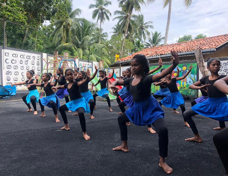 Children learn traditional dancing at a tsunami-hit village, in Seenigama, Sri Lanka