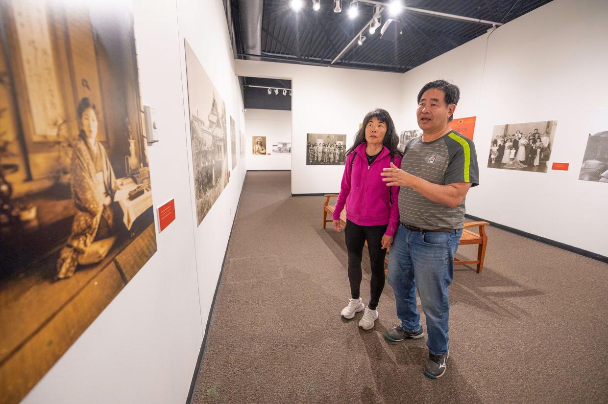 Kim Muramoto, left, and Dave Muramoto look at their grandfather's photographs while touring the El Pueblo History Museum exhibit Through the Lens: The Photography of Frank Muramoto, on Wednesday, May 10, 2023, in Pueblo, Colo.