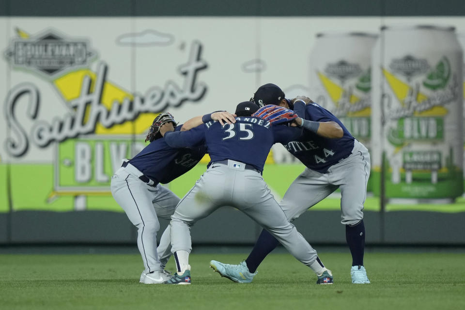 Seattle Mariners outfielders celebrate after their baseball game against the Kansas City Royals Tuesday, Aug. 15, 2023, in Kansas City, Mo. The Mariners won 10-8 in 10 innings. (AP Photo/Charlie Riedel)