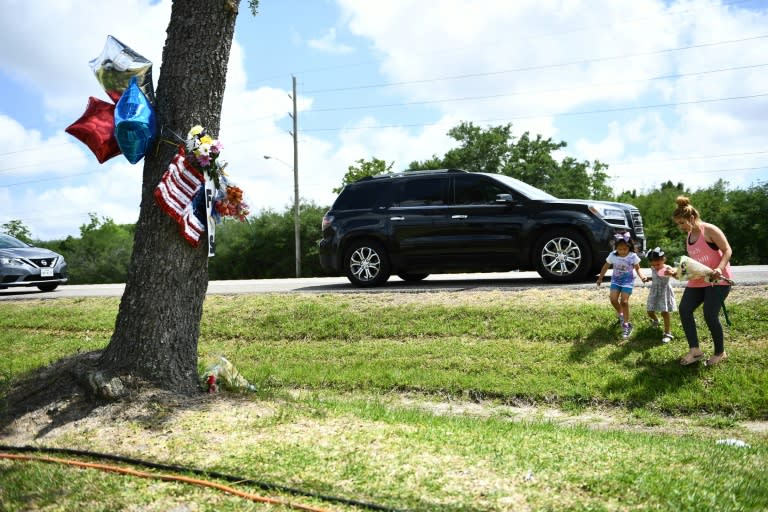 A family brings flowers to a makeshift memorial at Santa Fe High School in Texas, where the latest US mass shooting occurred