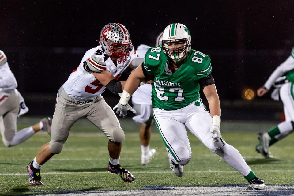 Mogadore senior Mason Williams runs around an offensive lineman to pressure the quarterback on defense during a regional semifinal football game against the Cuyahoga Heights Red Wolves on Saturday, November 12 in Twinsburg.