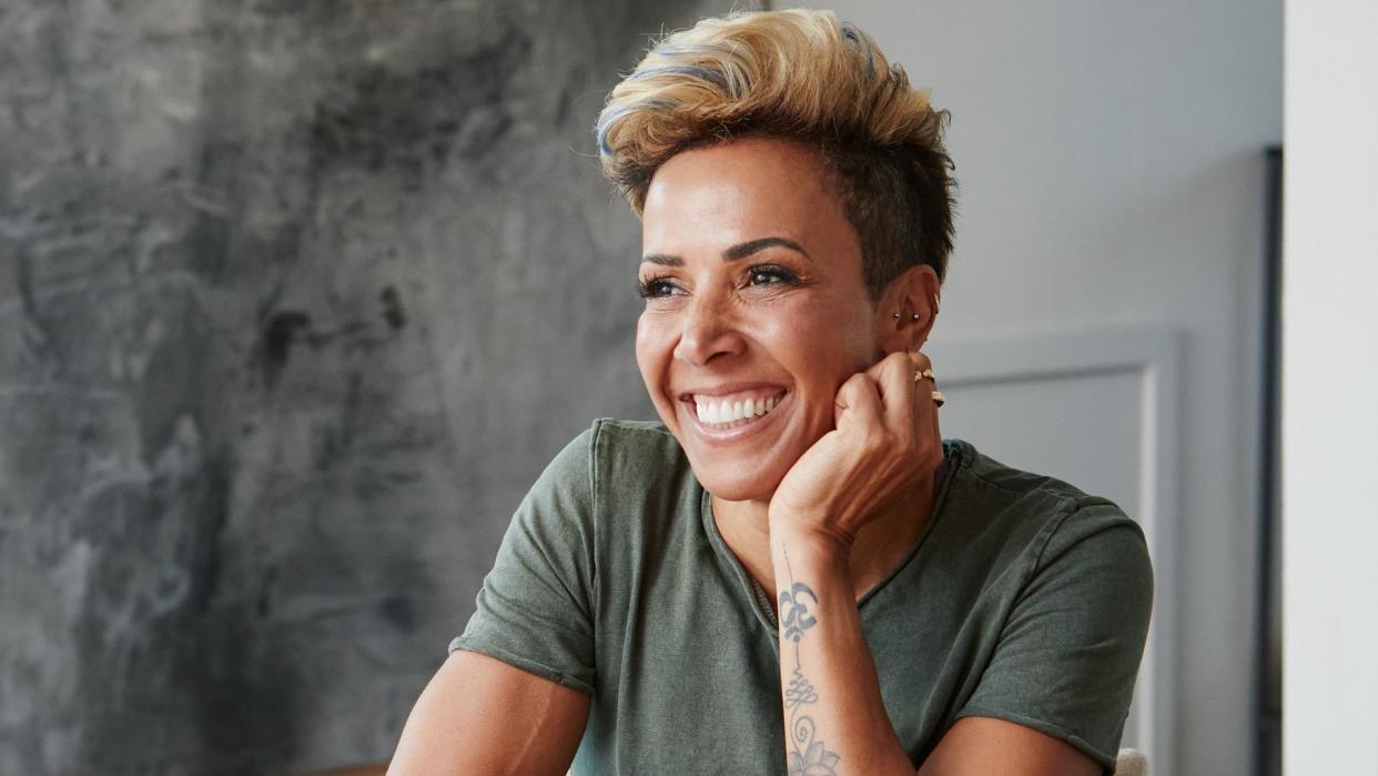 Dame Kelly Holmes grinning at a table 