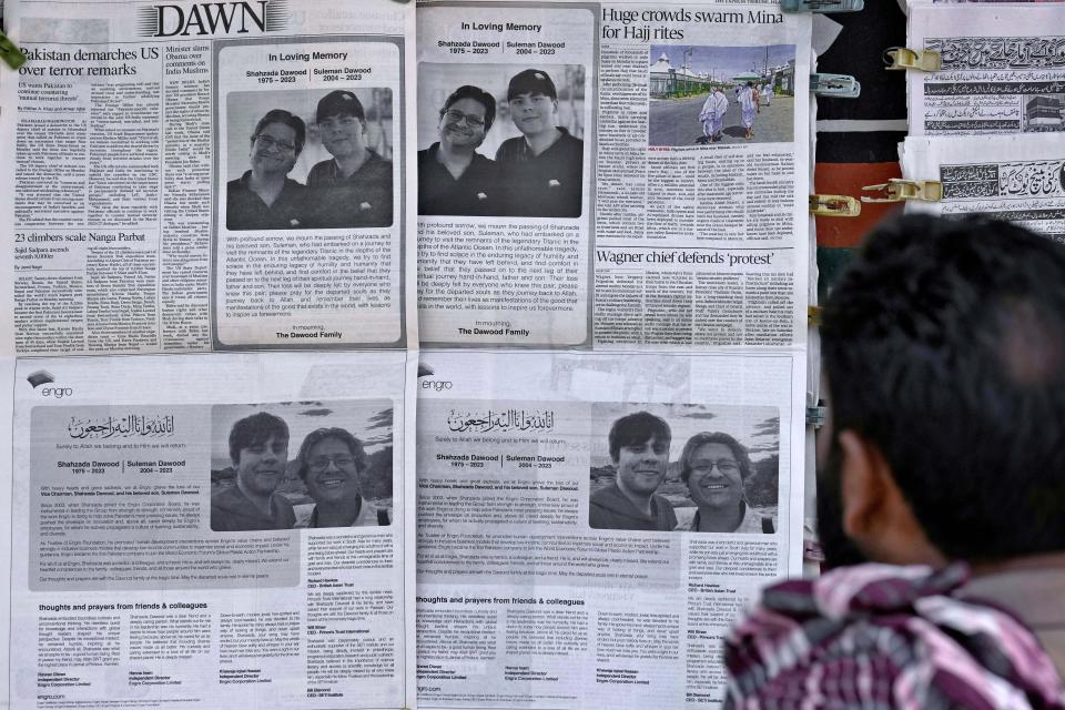 FILE-A man looks at morning newspapers which published condolence messages for two victims of Titan submersible incident, Shahzada Dawood and his son Suleman Dawood, at a roadside stall, in Islamabad, Pakistan, Tuesday, June 27, 2023. The deadly implosion of an experimental submersible en route to the deep-sea grave of the Titanic last June has not dulled the desire for deep-sea exploration. Tuesday, June 18, 2024, marks one year since the Titan vanished on its way to the historic wreckage site. (AP Photo/Anjum Naveed, File)