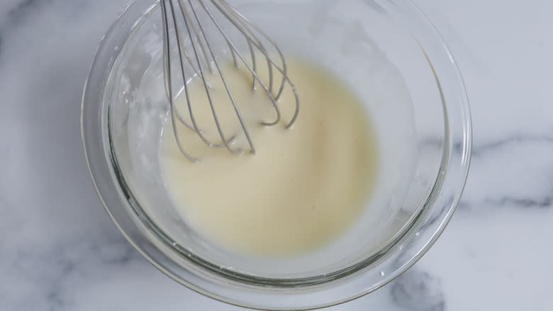 whisking cinnamon roll glaze together