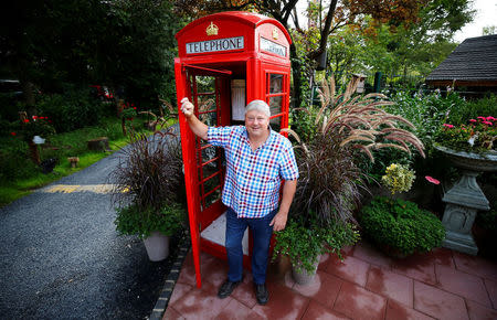 Gary Blackburn, a 53-year-old tree surgeon from Lincolnshire, Britain, is posing in front of his original British telephone box previously located at Trafalgar Square in London at his British curiosities collection called "Little Britain" in Linz-Kretzhaus, south of Germany's former capital Bonn, Germany, August 24, 2017. REUTERS/Wolfgang Rattay