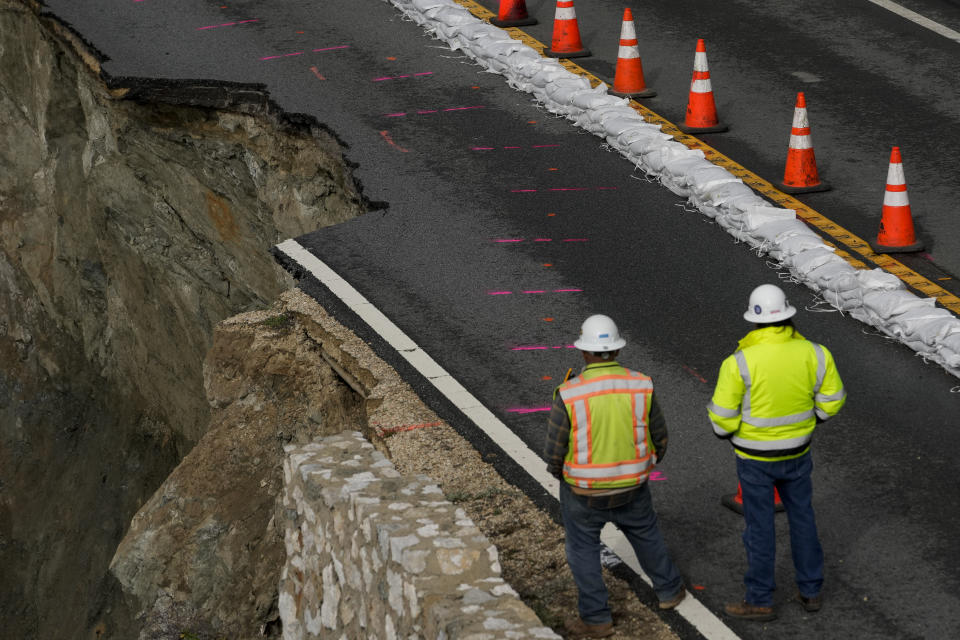 Construction workers look at the collapsed section of the southbound lane of Highway 1 at Rocky Creek Bridge, Thursday, April 4, 2024, in Big Sur, Calif. The break has caused the closure of the scenic road. (AP Photo/Godofredo A. Vásquez)