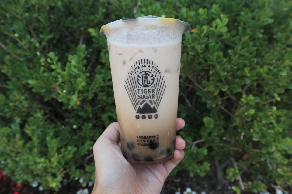 Bubble tea chain Tiger Sugar's black sugar boba black tea latte with cream mousse.