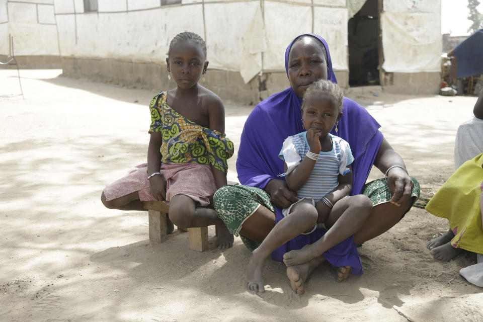 In this photo taken on Monday, Feb. 18, 2019, Fafa Malam, a woman and her children displaced by Islamist extremist sits outside her tent at Malkohi camp in Yola, Nigeria. Fafa Malam, from Gwoza, fled her home with her children in 2014 after her husband was killed by gunmen now she stays at Malkohi camp with hundreds of other displaced people, for whom the upcoming presidential vote isn’t a topic of conversation, because nearly all are more worried about putting food on the table.(AP Photo/ Sunday Alamba)