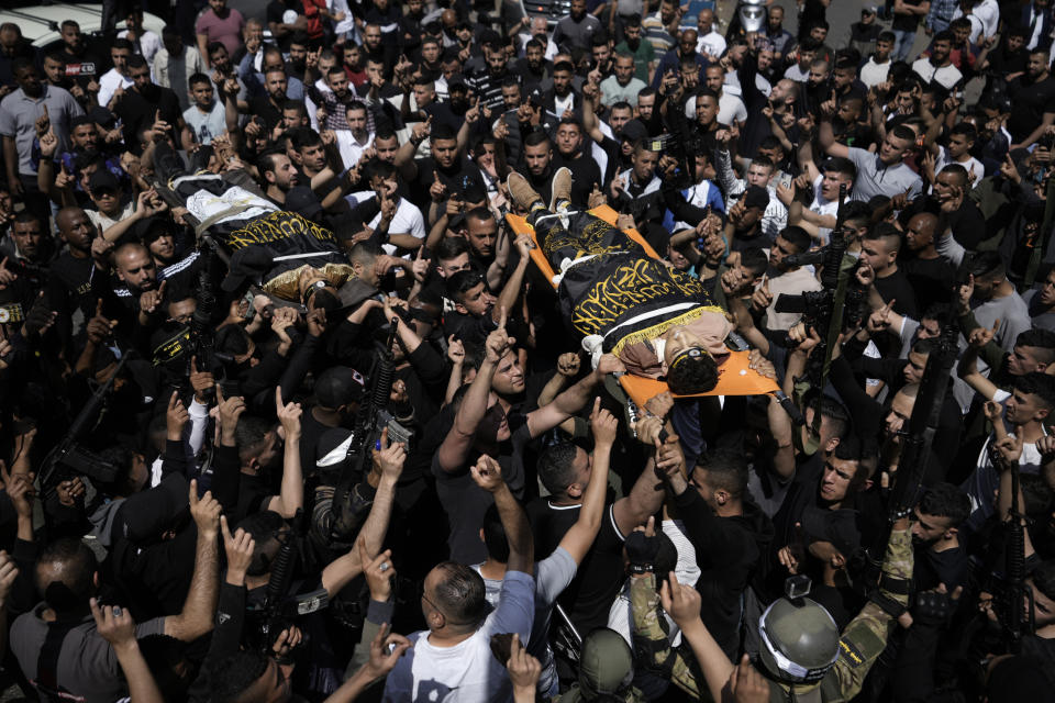 Mourners carry the bodies of Ahmed Assaf, 19, right, and Rani Qatanat, 24, left, draped in the flag of Islamic Jihad, two Palestinians killed by Israeli forces in Qabatiya, near the West Bank city of Jenin, Wednesday, May 10, 2023. The Israeli military said that Palestinian gunmen opened fire at troops in the Palestinian town of Qabatiya in the northern West Bank during an army raid. Troops returned fire, killing the two men, and confiscated their firearms, it said. (AP Photo/Majdi Mohammed)