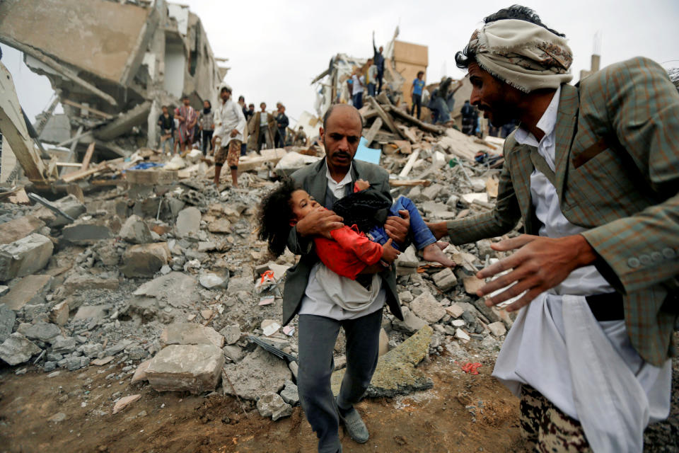 Buthaina Muhammad Mansour al-Raimi, believed to be 5, is carried from the site of the Saudi-led airstrike that killed eight of her family members in Sanaa, Yemen, on Aug. 25, 2017. (Photo: Khaled Abdullah/Reuters)