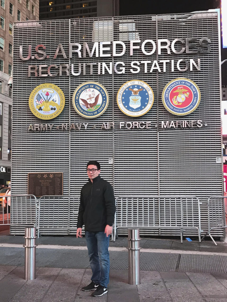 This November 2017 photo provided by Badamsereejid Gansukh shows him in front of a U.S. military recruiting office in New York's Times Square. Gansukh, whose recruiter told him his Turkish language skills would be an asset to the military, said he didn’t know he was discharged at all until he asked his congressman’s office in the summer of 2018 to help him figure out why his security screening was taking so long. (Courtesy of Badamsereejid Gansukh via AP)