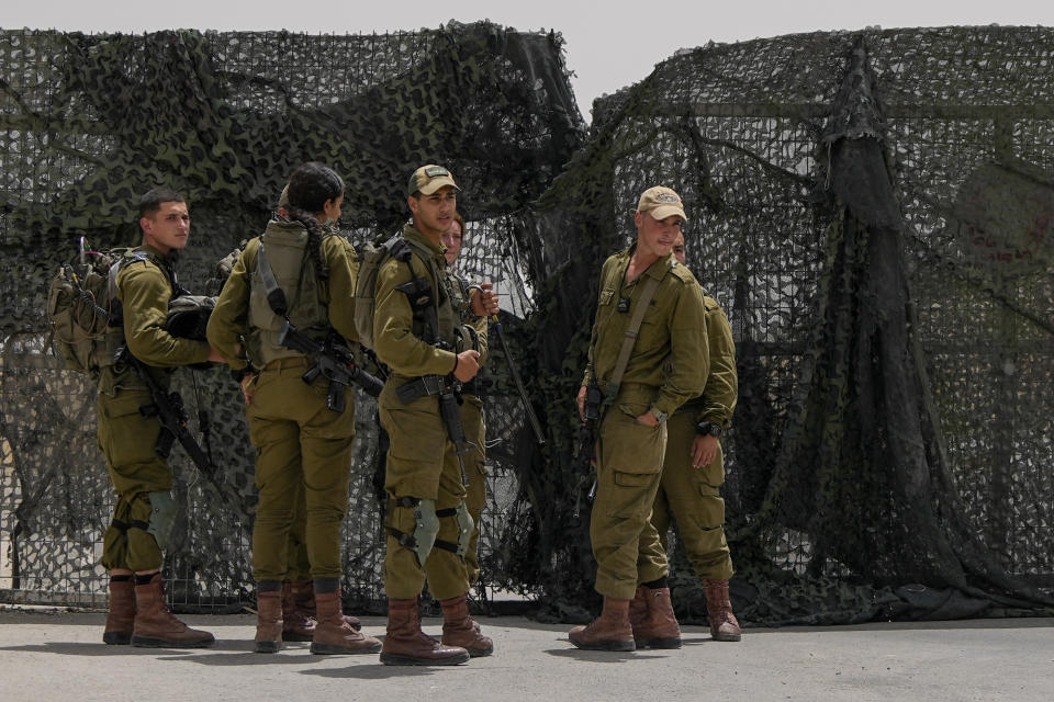 Israeli soldiers gather in front of a gate of military base following a deadly shootout in southern Israel along the Egyptian border, Saturday, June 3, 2023. (AP Photo/Tsafrir Abayov)